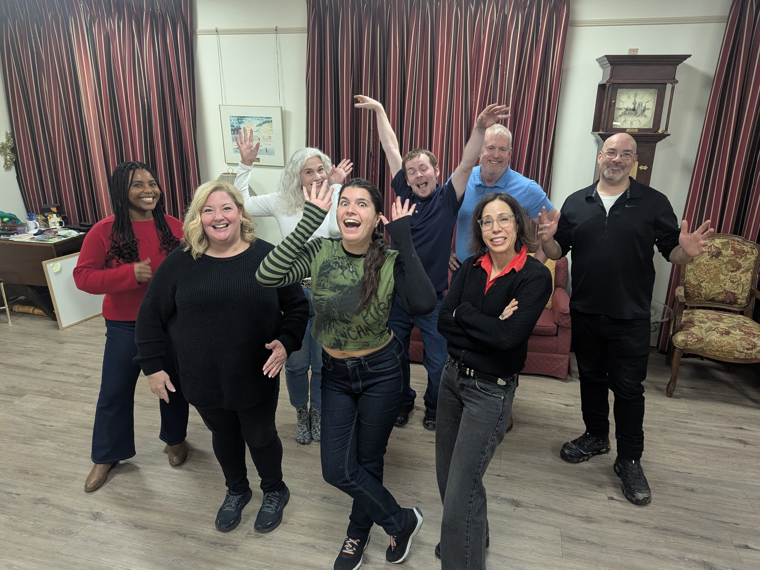 A smiling group gathered at an evening Railway City Improv class